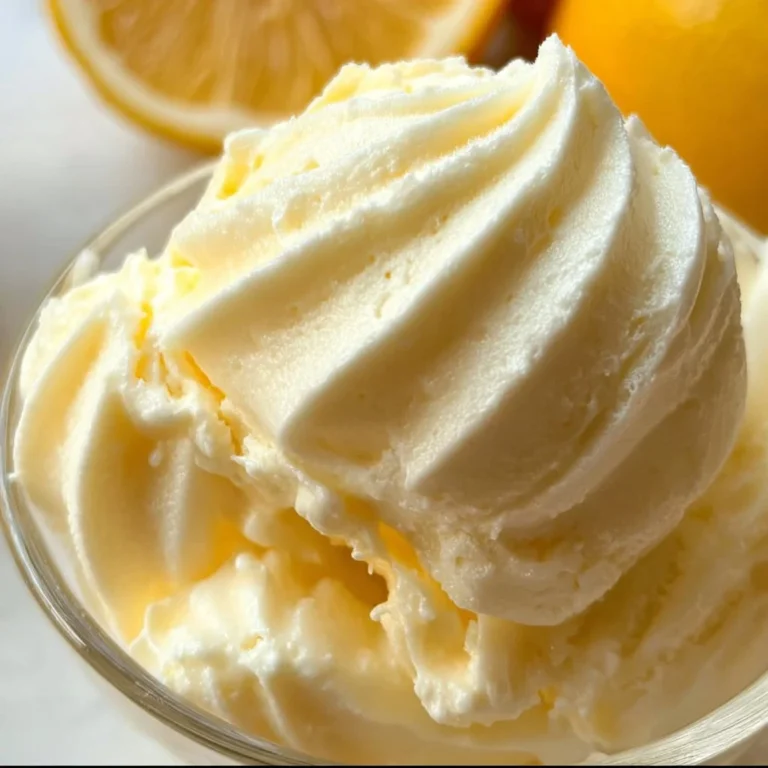 A bowl of creamy lemon frozen yogurt garnished with lemon slices.